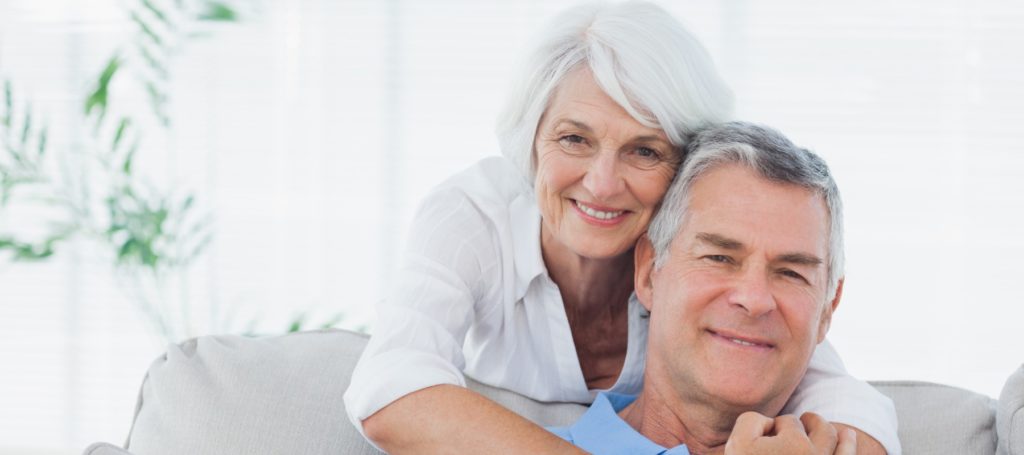 woman embracing husband sitting on the couch picture id846888016